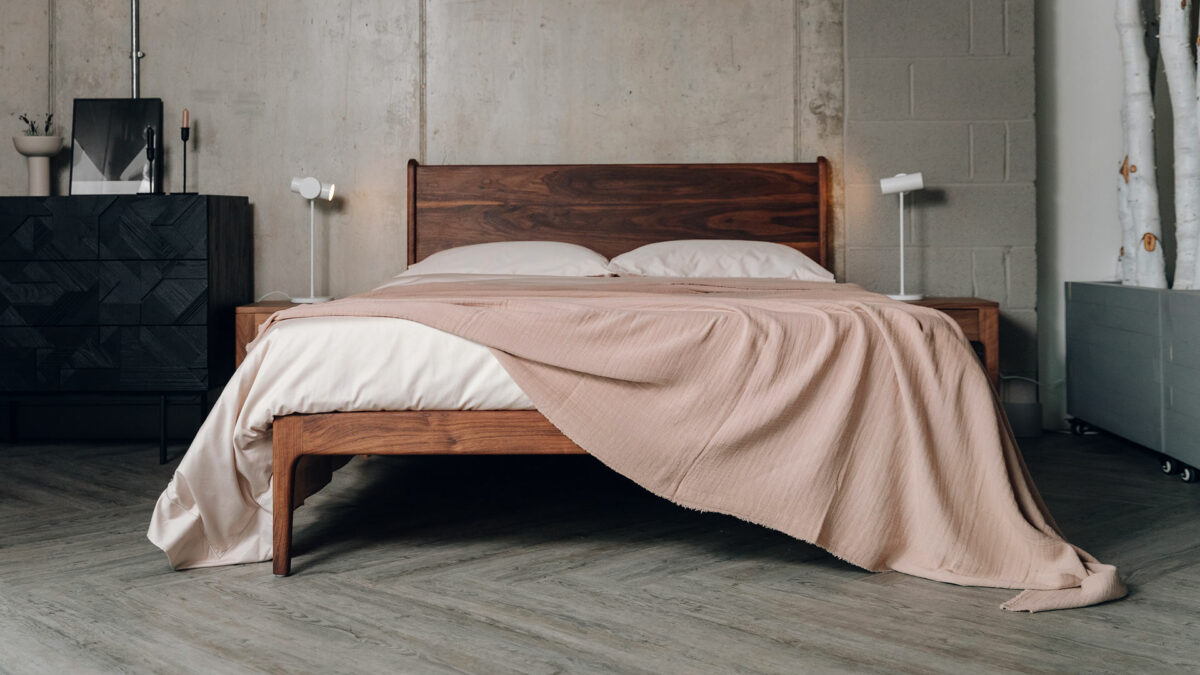 shell coloured cotton bedding shown with a blush pink light textured bedspread shown on an oiled walnut kingsize Camden bed