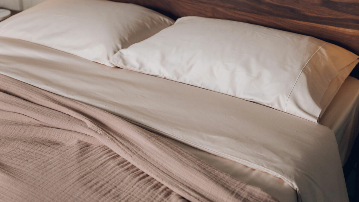 shell coloured cotton duvet set shown with a rose coloured textured bedspread