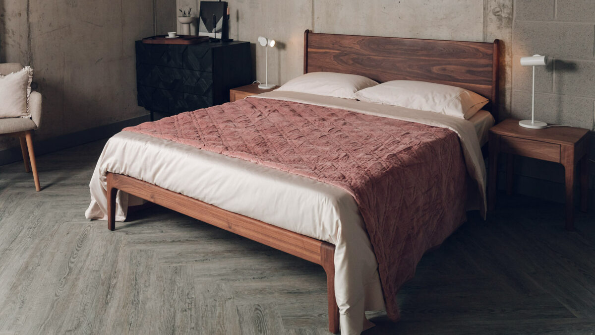 dusky rose coloured quilted velvet bedspread shown on a kingsize wooden bed