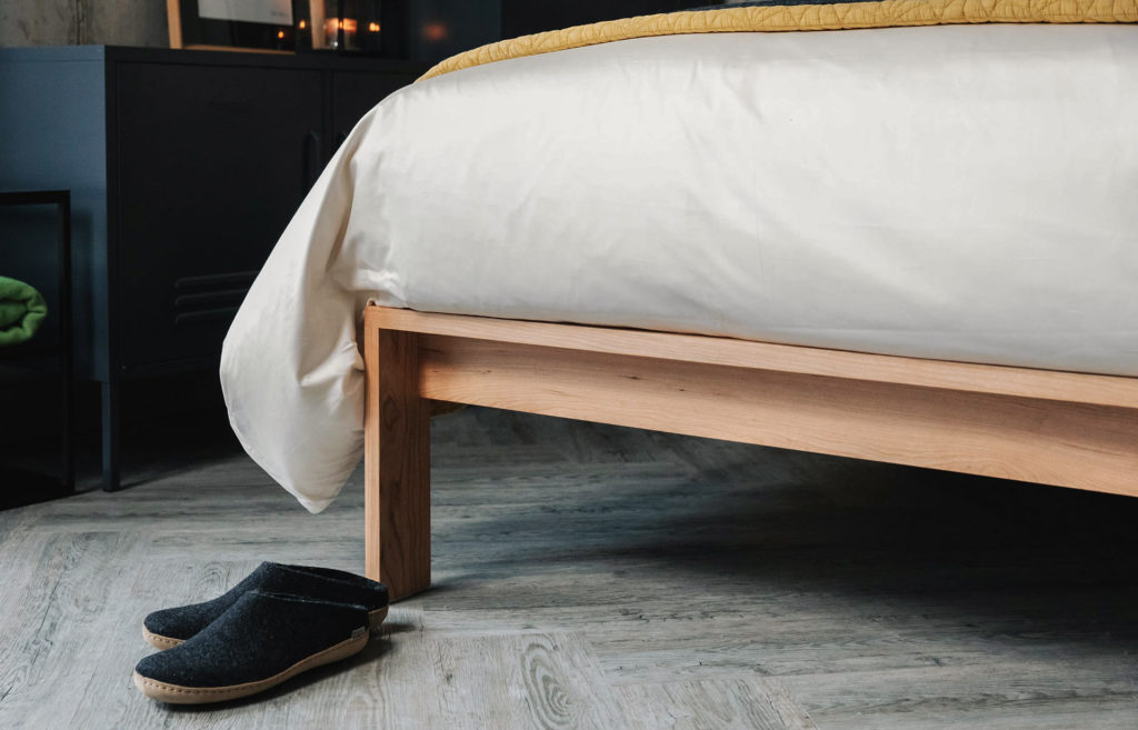 Charcoal Glerups Slippers in a closer view of the Shetland wooden bed leg joint.