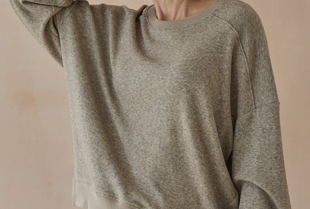 Model wearing grey soft knit sweatshirt with matching joggers.