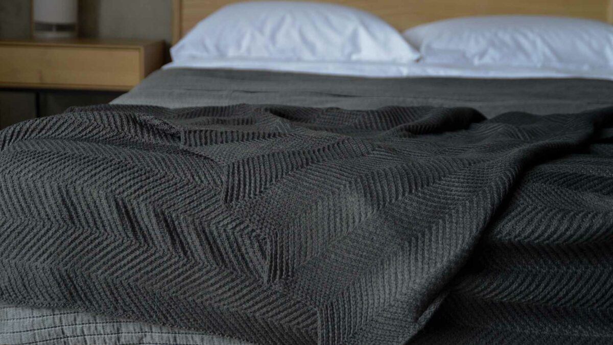 charcoal knitted throw with chevron pattern and scalloped edges