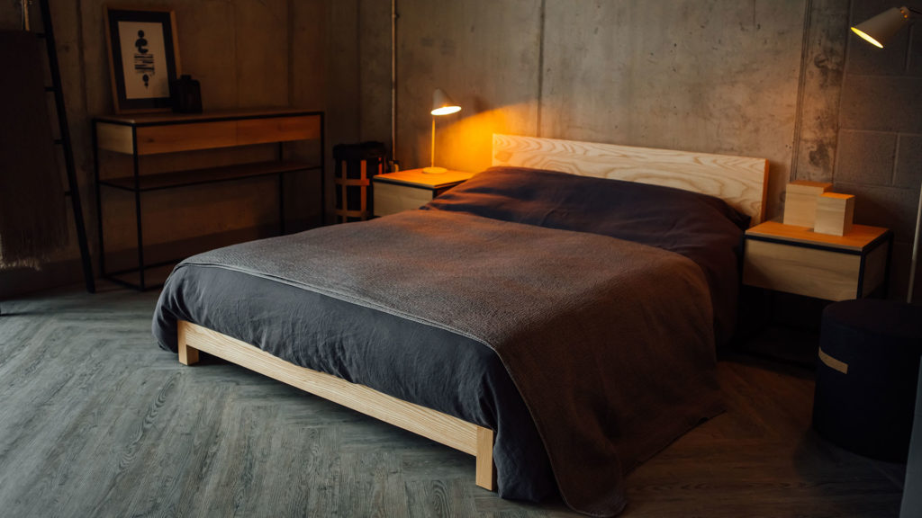 Nordic style hand made low wooden bed in ash, the Sonora shown with slate linen bedding