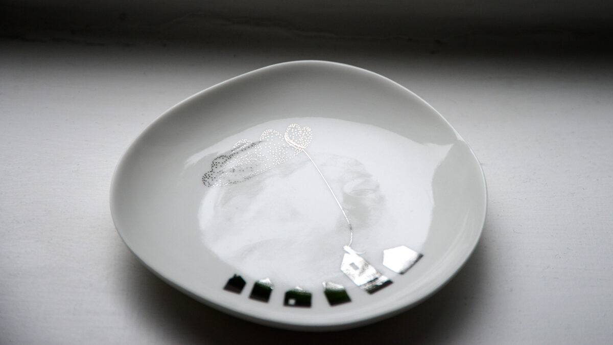 small dish with houses and cloud design in silver