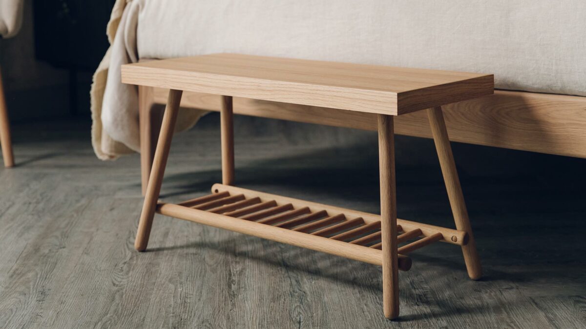 small oak bench with a lower spindle storage shelf