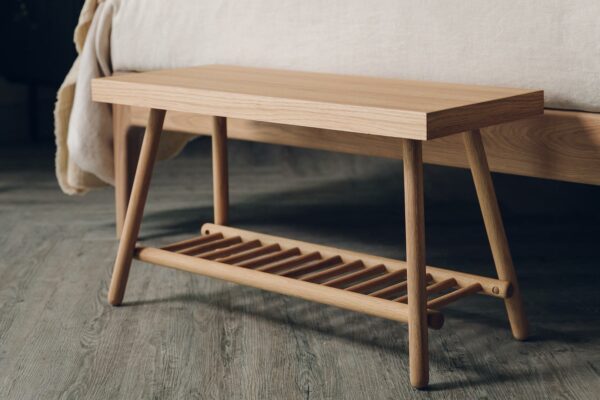 small oak bench with a lower spindle storage shelf