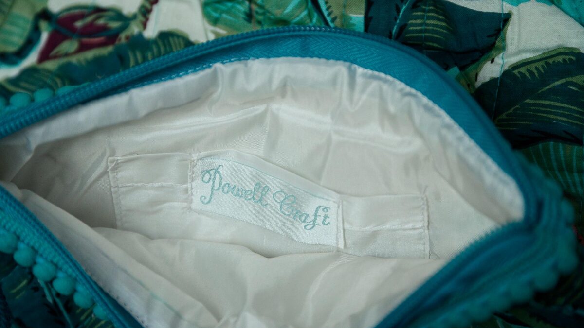 close up of silky lining inside on tropical print teal toiletry bags.
