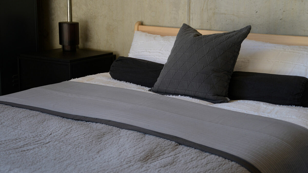 stitched stripe quilted bedspread in silver grey with a dark grey border