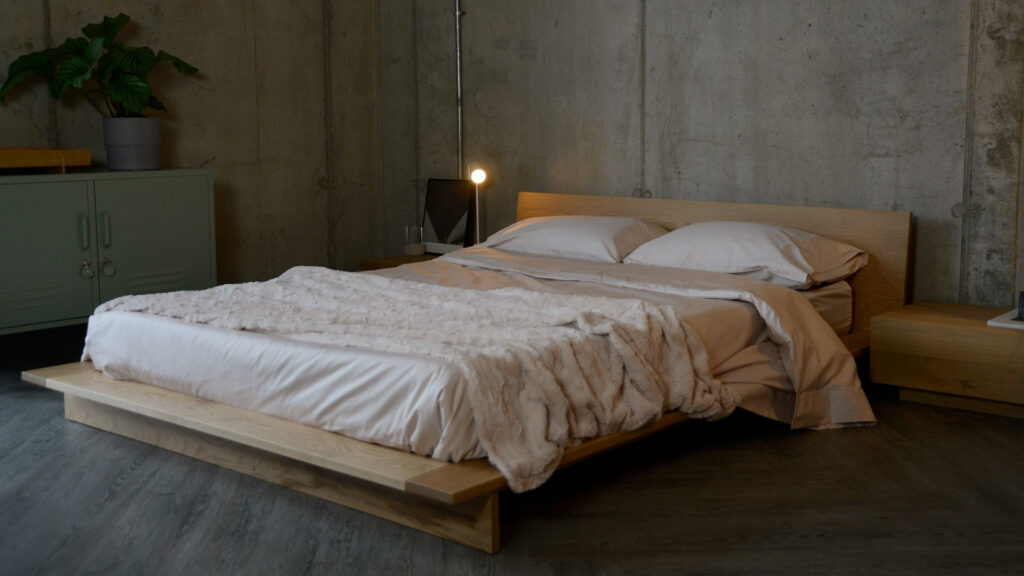 soft sheen Egyptian cotton bedding in oyster colour shown on a low bed