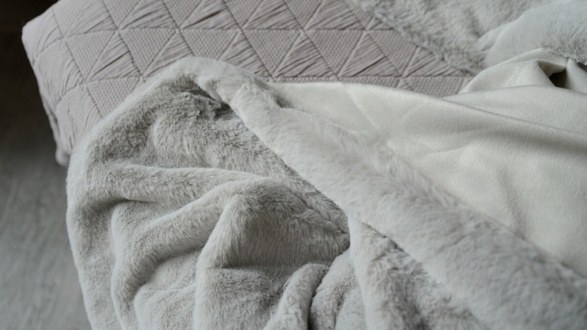 a close-up view of the soft pale grey faux fur blanket