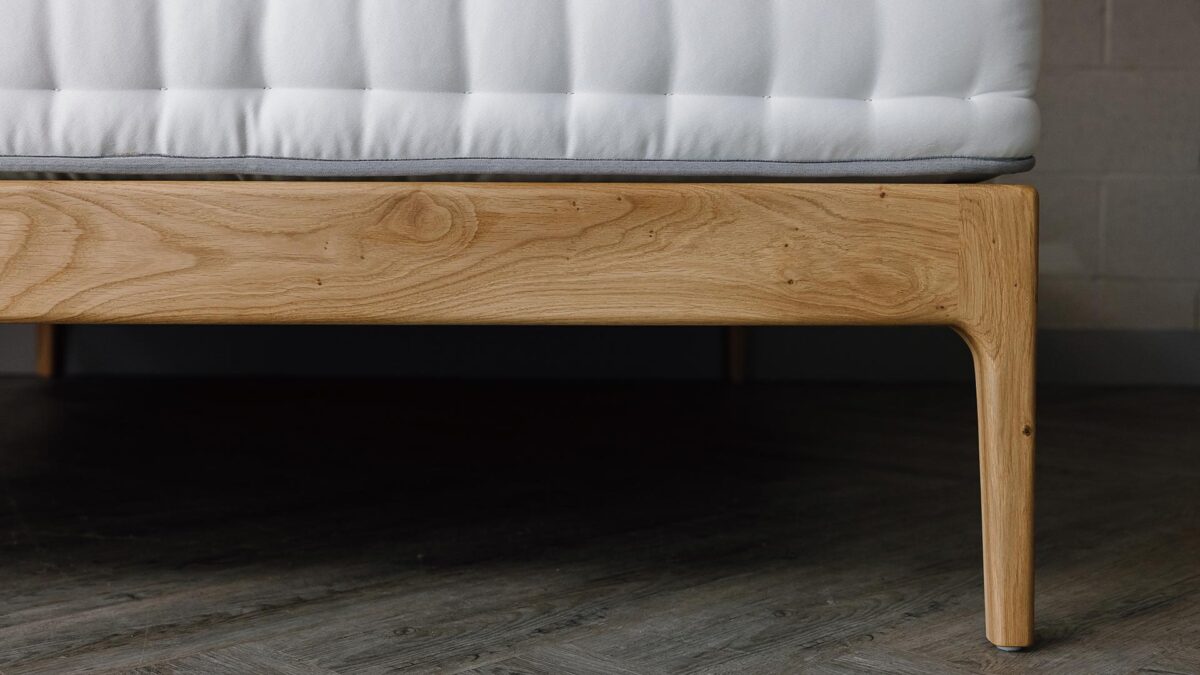 A close up shot of part of the English oak Chiswick's foot-rail/leg, showing the detailed swirls and small knots in the timber.