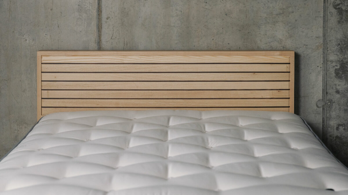 A special edition Leith bed in Ash wood with walnut stripes to the headboard panel a view of the headboard from the front