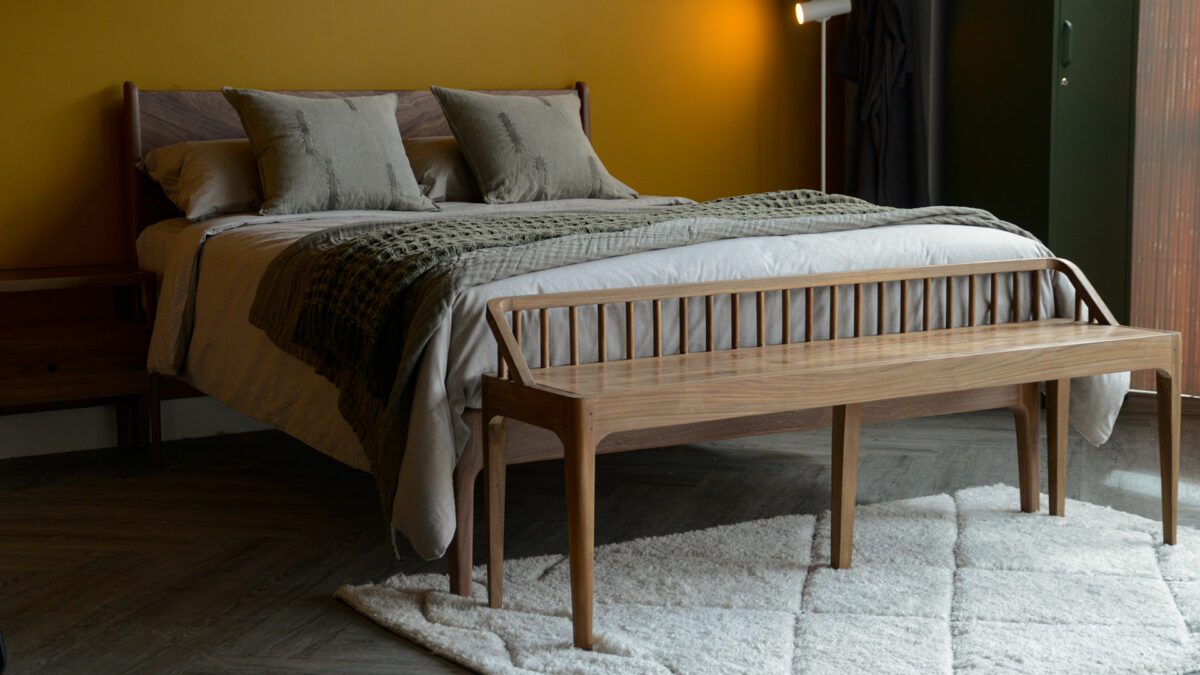 spindle becnh in recalimed teak in front of walnut Hoxton bed