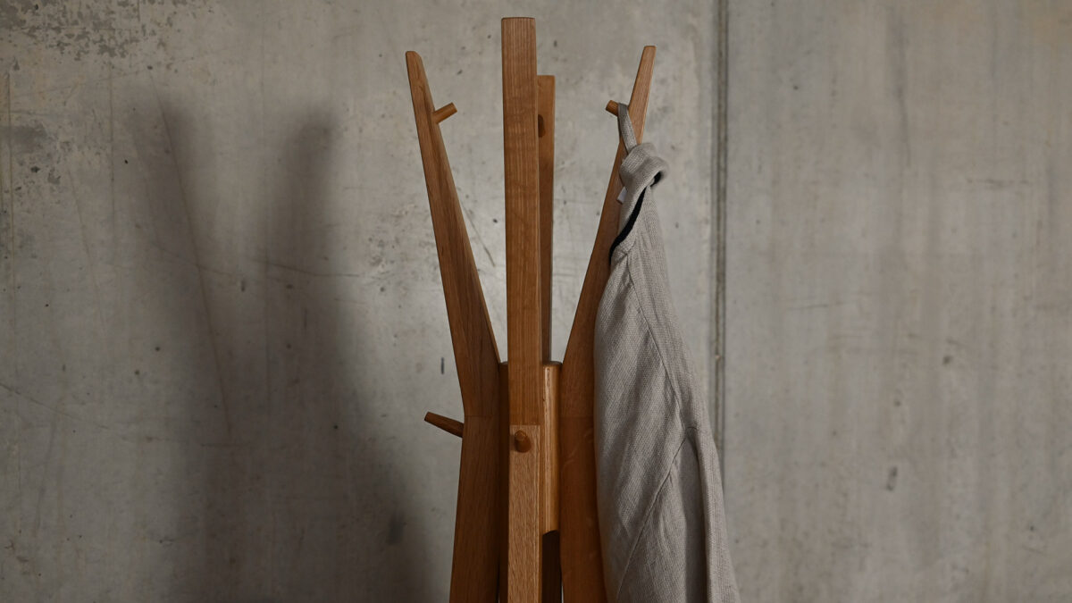 Detail shot of top section of Spire coat stand with cotton robe hanging from it.