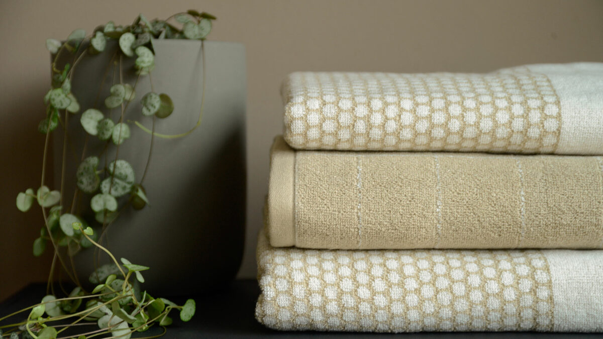 stack of beige and white towens with plant