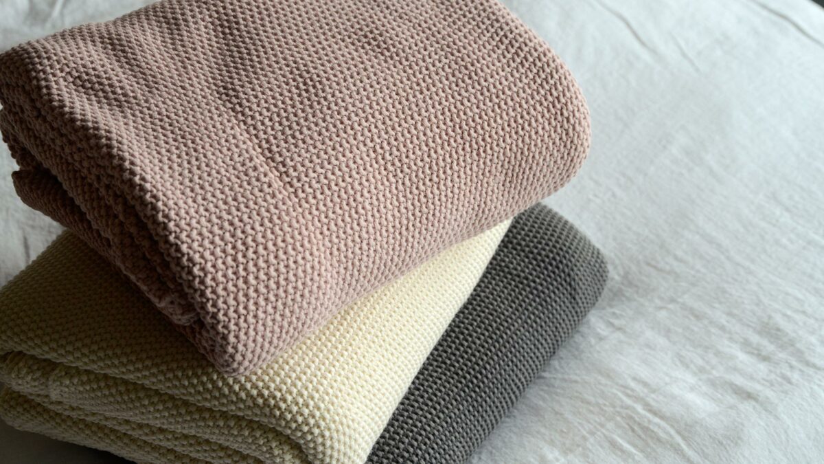 moss stitch knitted cotton throws in blush, cream, and grey