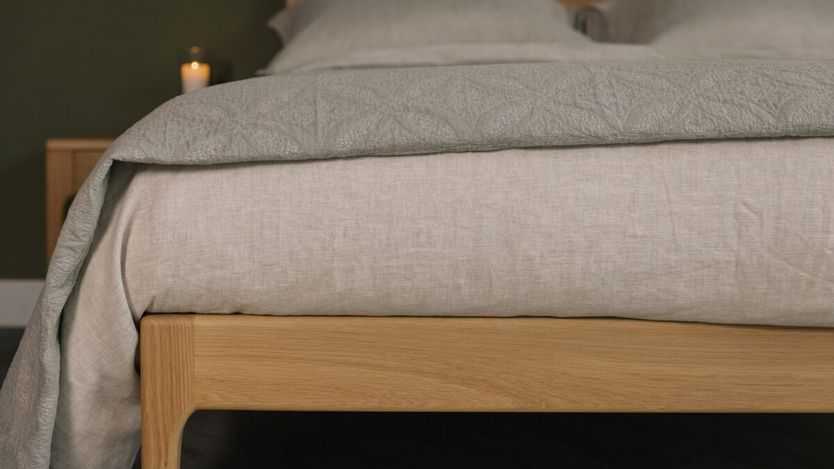 stone and taupe bedding on oak bed