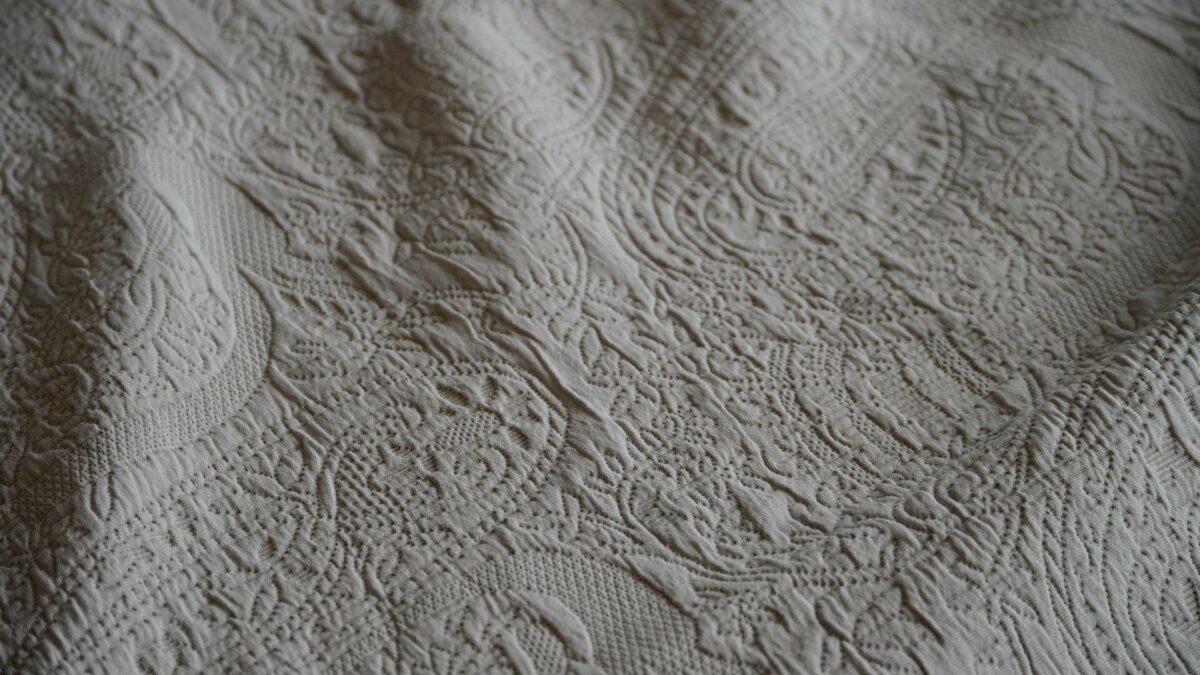 modern bedspread with a textured paisley pattern design