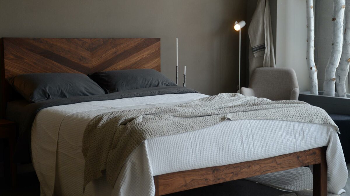 waffle weave cotton throw in a stone colour shown on a kingsize bed