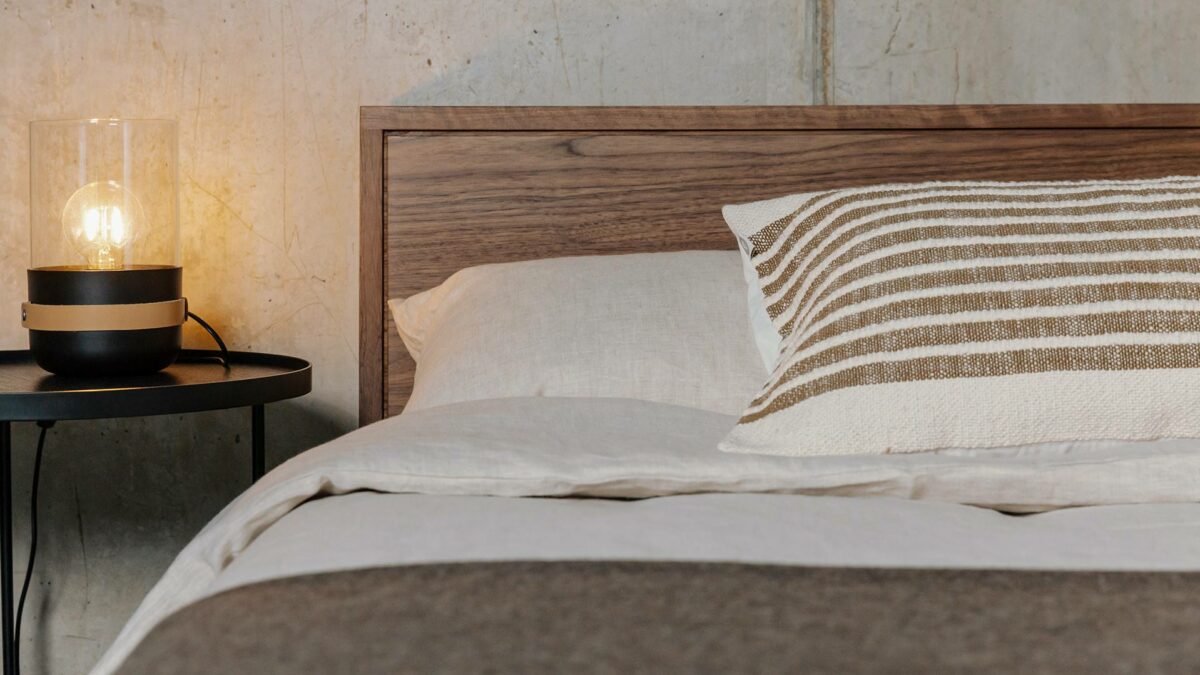mid century style headboard of the Walnut Leith bed with neutral bedding