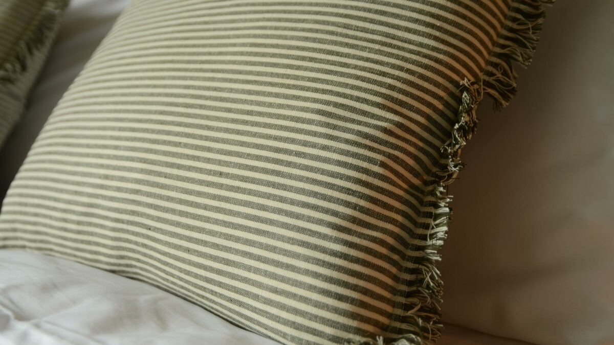 striped cushion in cream and dark green with fringe detail