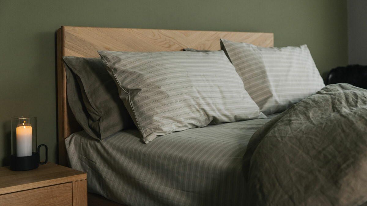 sage green striped fitted sheet and pillowcase set shown on a bed