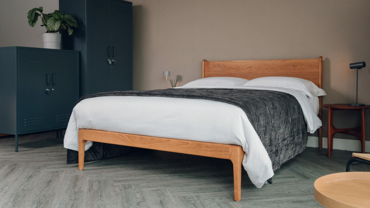 luxury quilted bedspread in charcoal grey velvet shown on a Kingsize cherry wood Camden bed