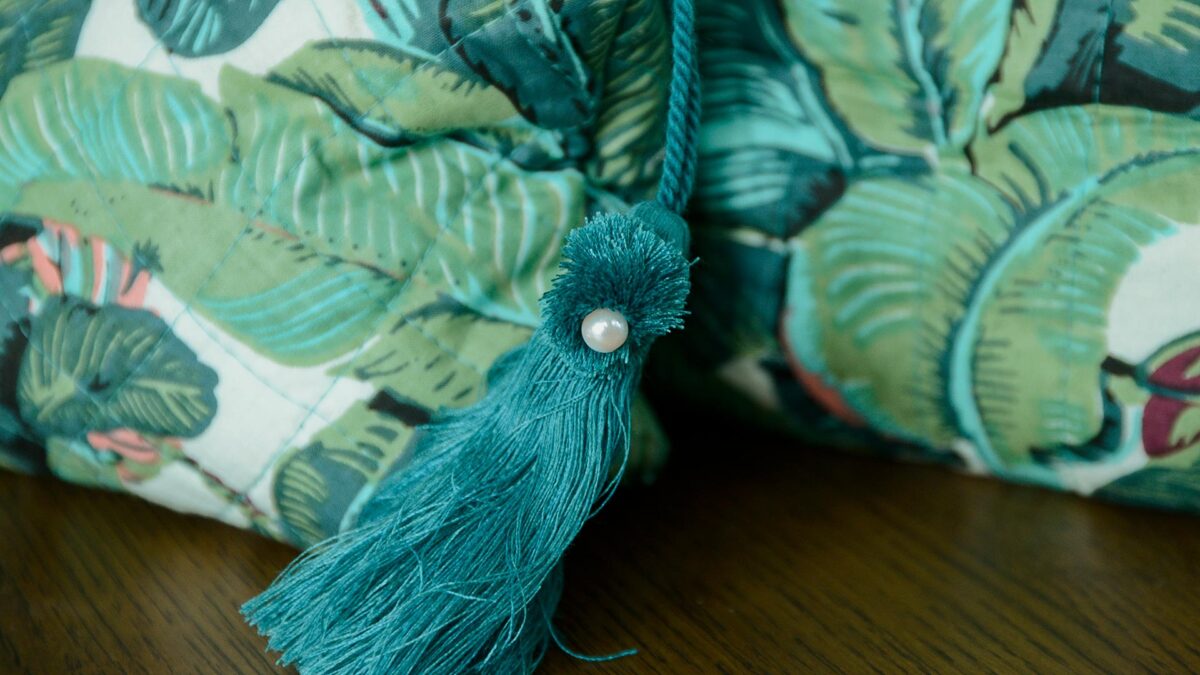 Close up of teal tassel with pearl detail.