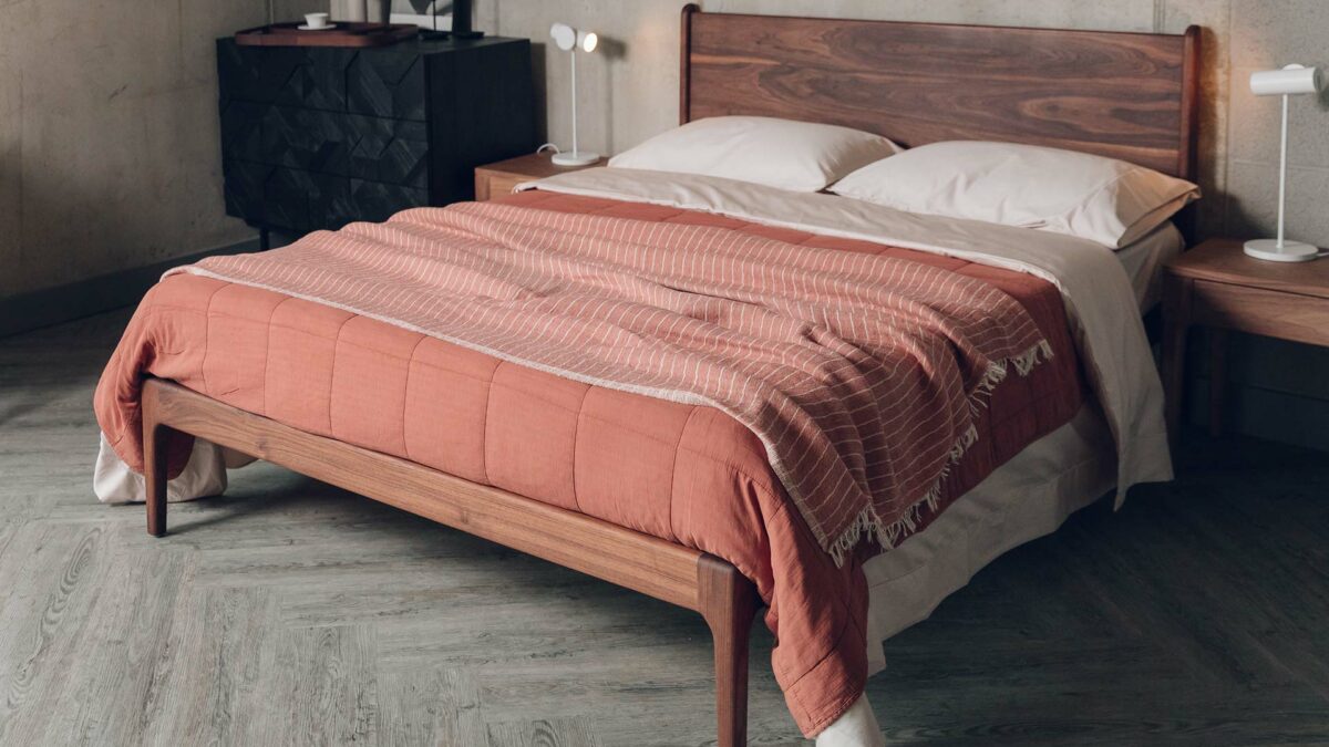 oiled walnut Camden bed shown with blush pink cotton bedding and terracotta bedspreads