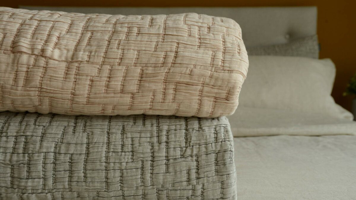 lightly quilted and textured crinkle effect bedspread sets in warm grey and blush pink