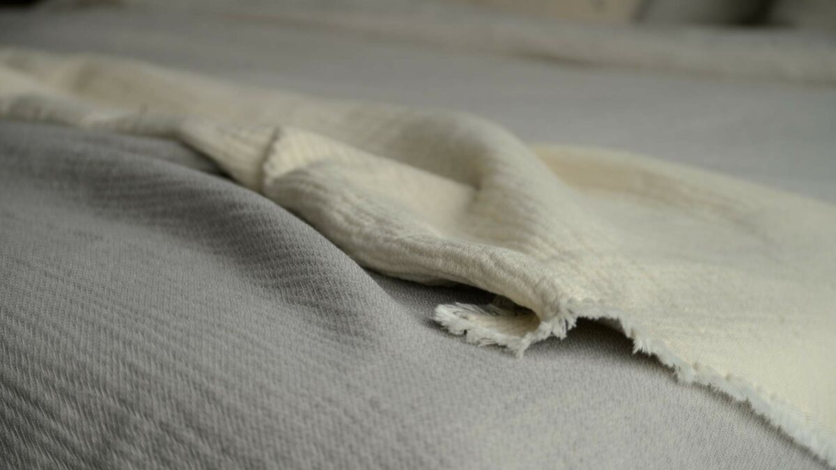 organic cotton textured bed throw in grey and ivory a close up view