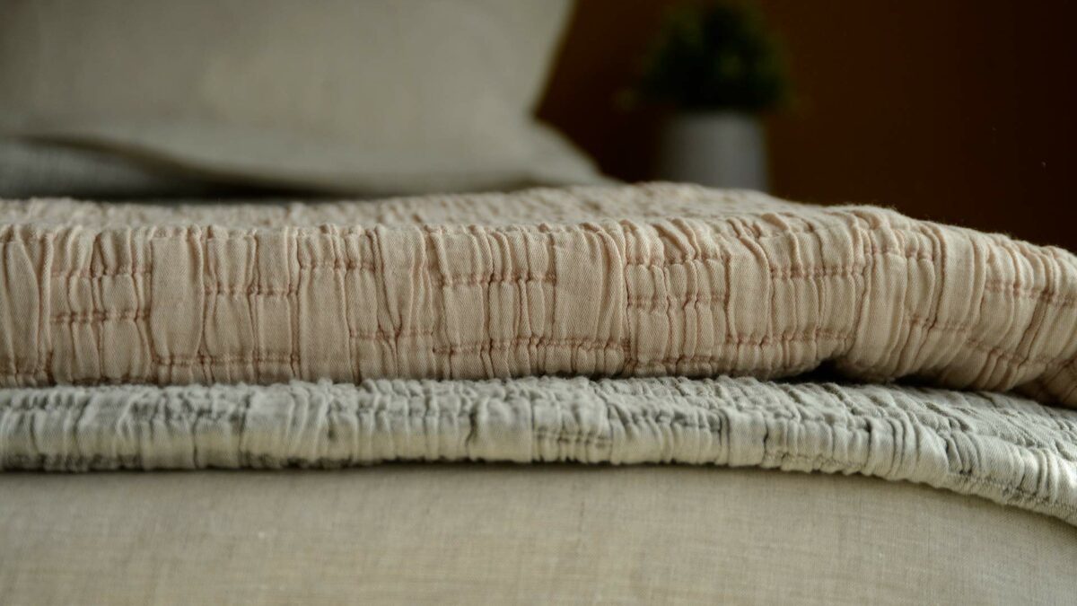 lightly quilted and textured crinkle effect bedspreads in warm grey and blush pink