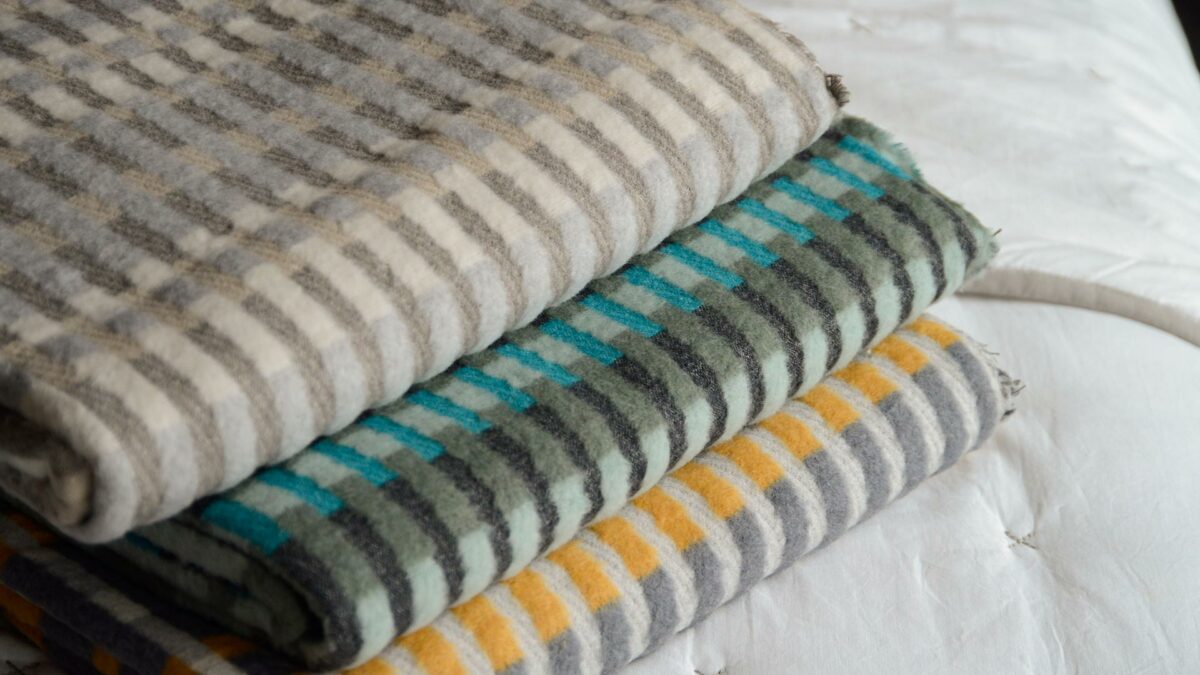 patterened fluffy throws in a choice of colours shown together in a stack