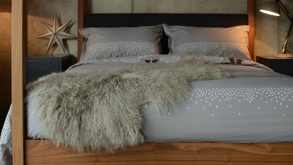 tibetan-lamb-fur-throw-pale-grey-on-log-cabin-print-bedding