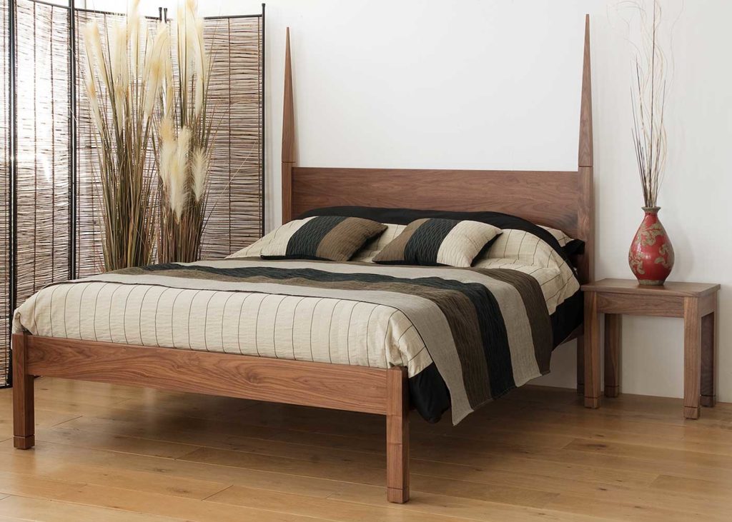 A striking exotic bed with tall posts, the solid wood Togo bed