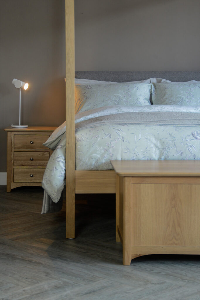 traditional style oak bedside table with 3 drawers shown with our Highland bed