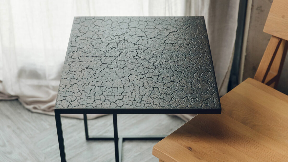 metal framed side table with a cracked lava effect top