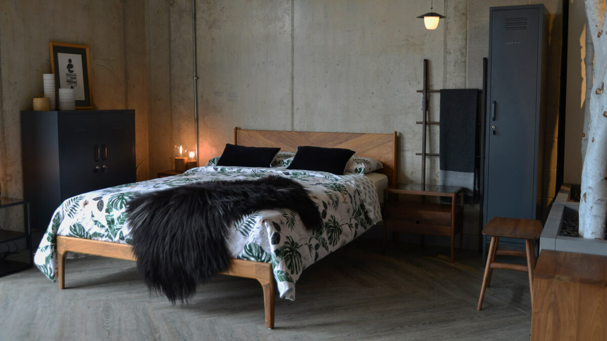 Industrial style bedroom featuring our hand made Hoxton bed in walnut with grey storage lockers and patterned bedding.