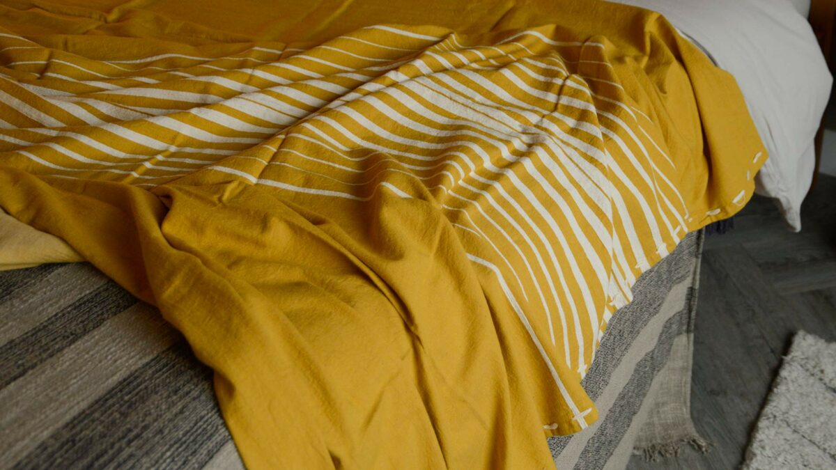 deep yellow cotton throw with printed ivory stripe and grey tassel