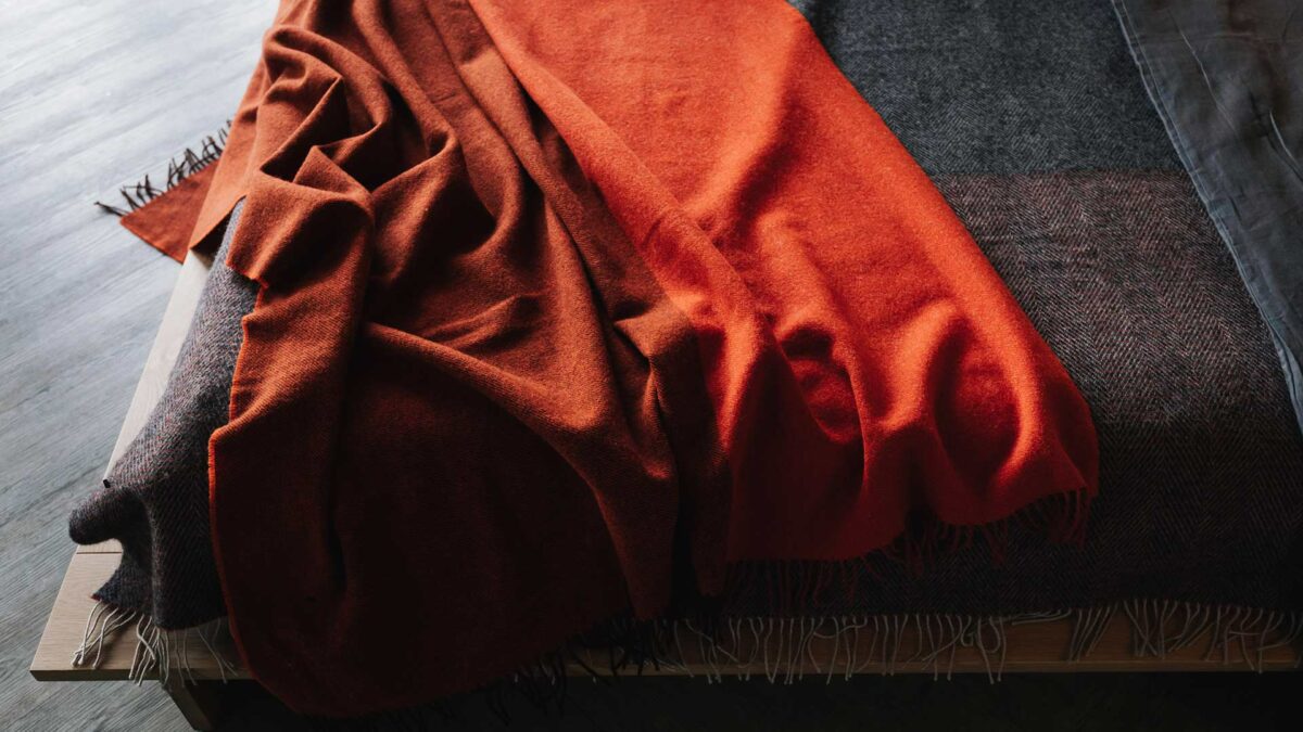 100% pure wool colour block throw in a warm orange colour with brown undertones