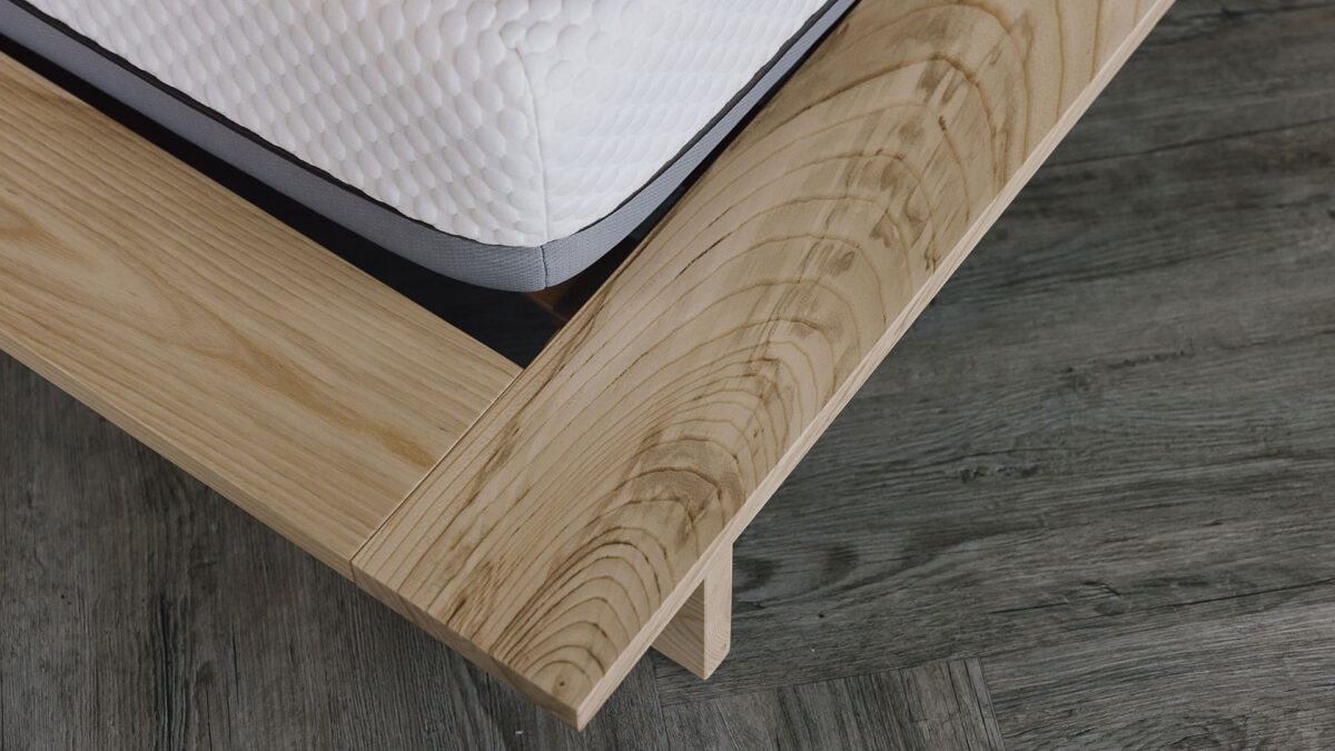 Close up of the corner of an ash platform bed frame. Image highlights the unusual grain pattern of the ash.