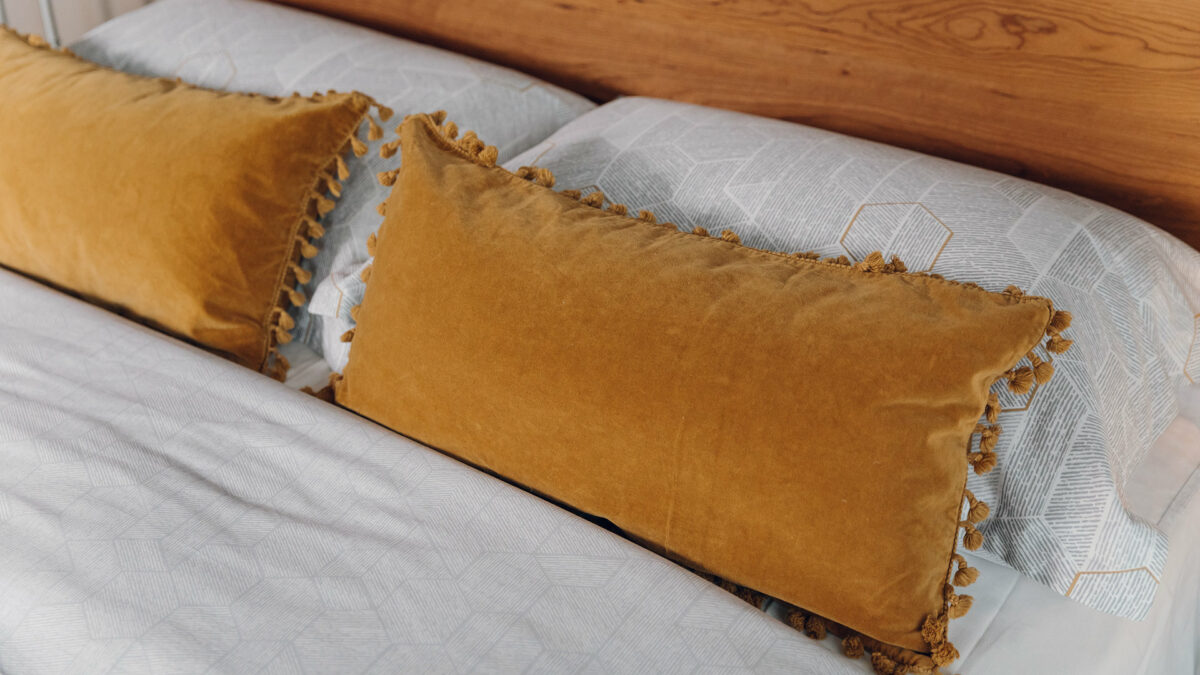 ochre coloured velvet cushions with tasselled edges