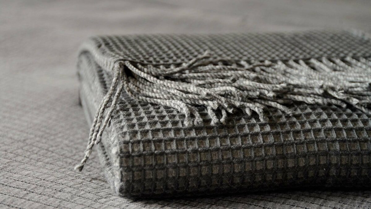 modern waffle knit throw in shades of grey and shown folded