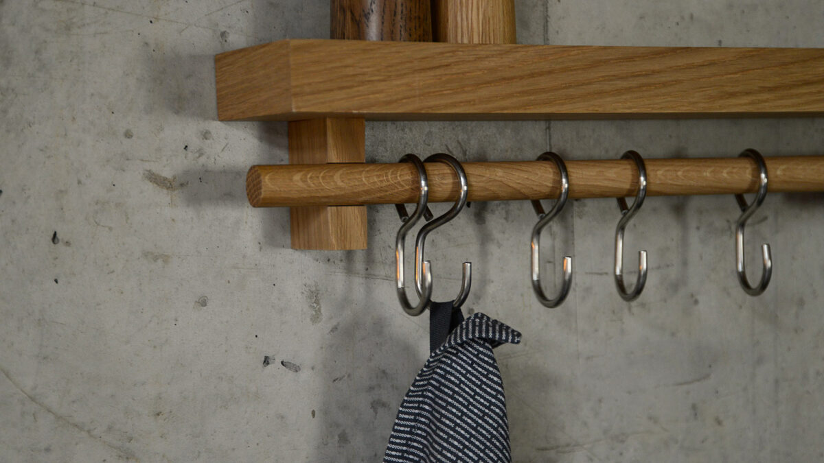 wall-mounted oak storage shelf with rail and hooks