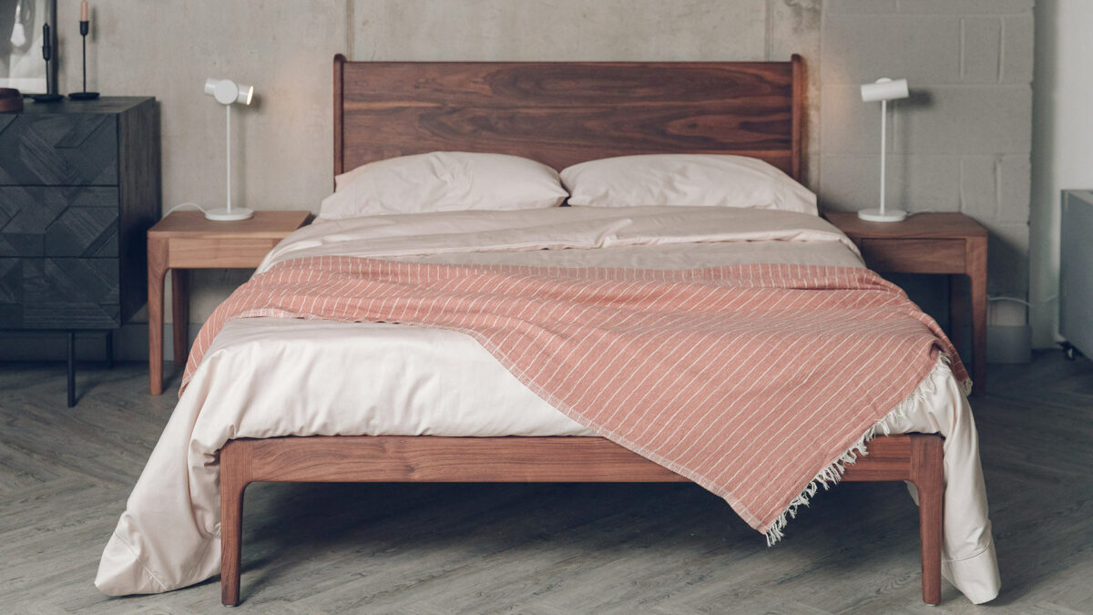 walnut Camden bed from front with shell colour beddijg and striped throw