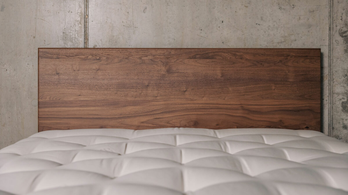 a view of the front of the headboard of a walnut wood Chiswick bed