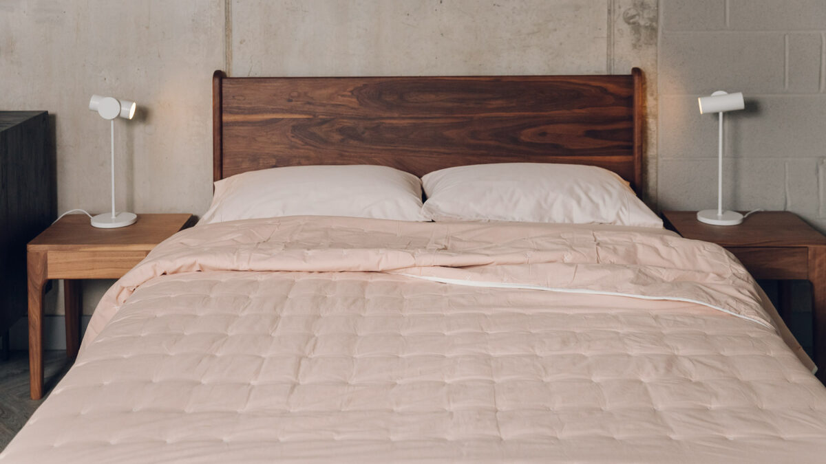 blush pink quilted cotton bedspread shown on a kingsize bed