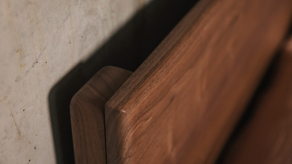 a close up of the Chiswick bed wooden headboard made from solid walnut