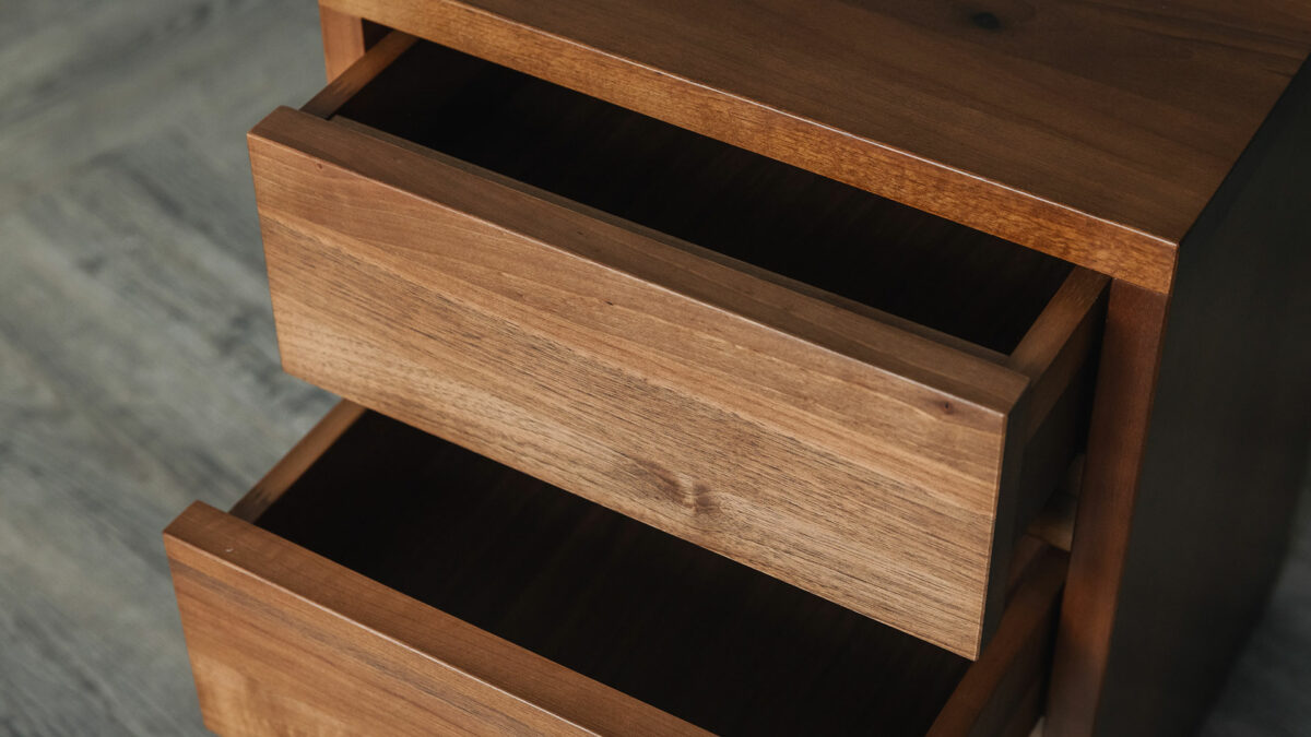 a close up view of the open drawers of our solid walnut wood two drawer bedside table