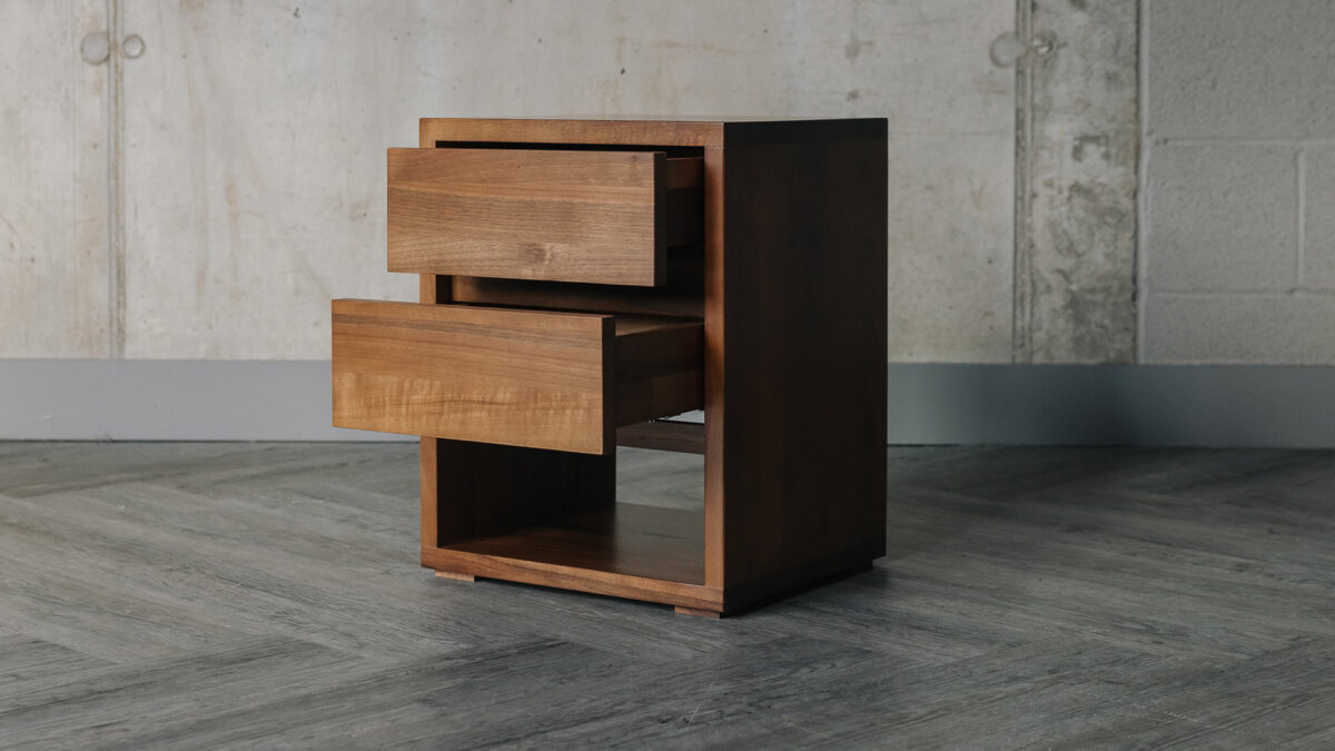 solid walnut wood two drawer bedside table with open shelf shown from the side and with open drawers